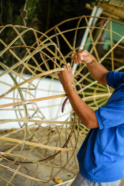 Hombre haciendo objeto de bambú a mano
 - Foto, imagen