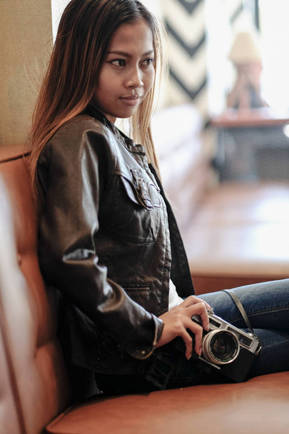 Gorgeous young woman in leather jacket, holding Vintage Retro film camera. Hipster,  Vintage Retro fashion style - Foto, Imagen