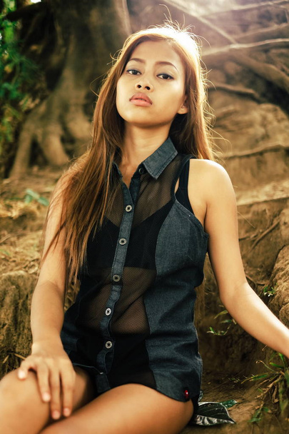 Young sexy, beautiful Asian girl sitting on the hill ground - Valokuva, kuva