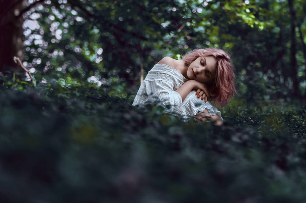 Schönheit Frau in märchenhafter Natur Landschaft. von Kopf bis Fuß gebeugt im Gras sitzend - Foto, Bild