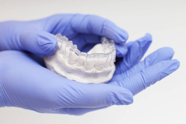 Primo piano vassoio dentale individuale Tema ortodontico dentale. In mano Bretelle invisibili - Foto, immagini