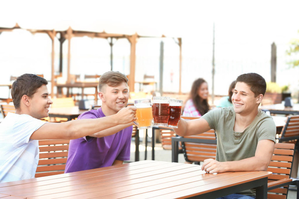 Guys drinking beer in pub - Фото, зображення