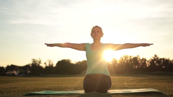 Γυναίκα καταλληλότητας άσκηση γιόγκα θέτει στο ηλιοβασίλεμα - Πλάνα, βίντεο