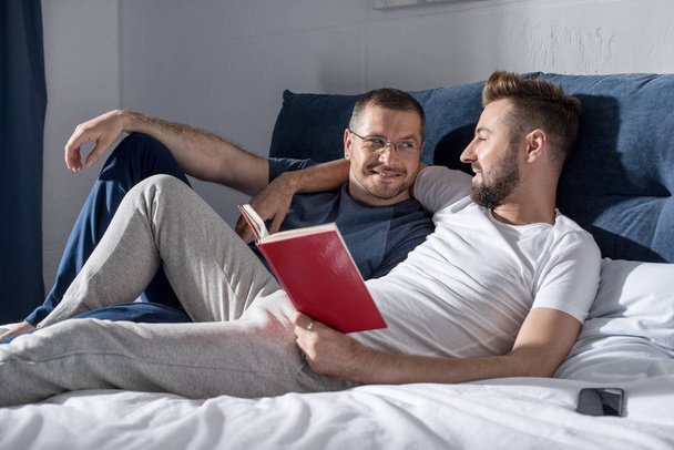 Homosexual couple reading book  - Foto, Imagen