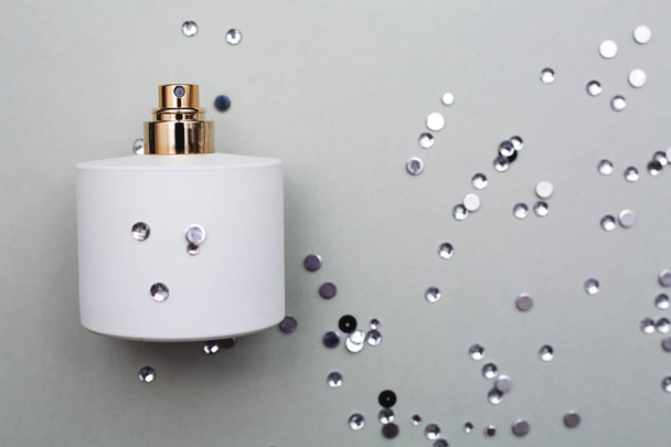 fles parfum in grijze achtergrond - Foto, afbeelding