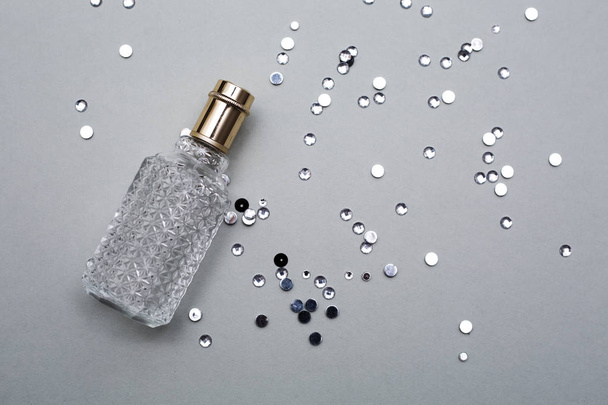 Perfume de botella femenina sobre fondo gris
 - Foto, imagen