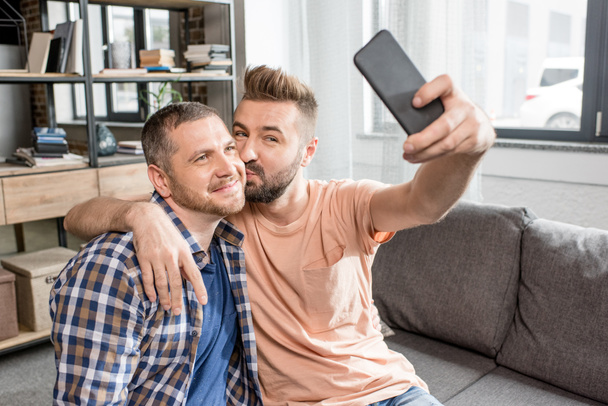pareja homosexual tomando selfie en smartphone
 - Foto, Imagen