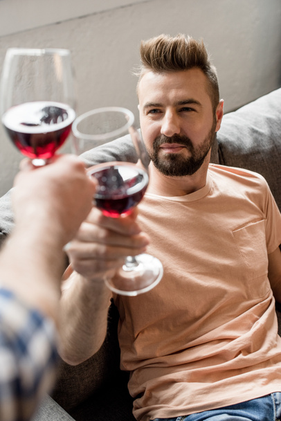 homosexual couple clinking with wine at home - Zdjęcie, obraz