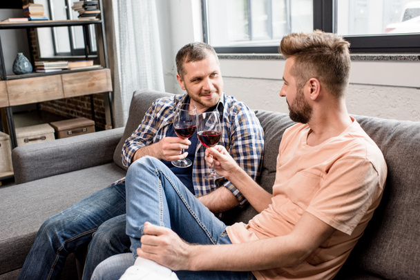 casal homossexual clinking com copos de vinho
 - Foto, Imagem