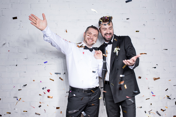happy homosexual couple celebrating with confetti - Фото, изображение