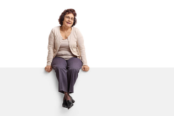 Senior woman sitting on a panel - Foto, imagen