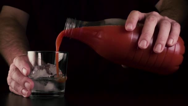 Slow mo. gießen Sie den Saft in ein Glas mit Wodka - Filmmaterial, Video