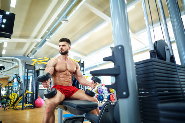 Bodybuilder with dumbbells in the gym - Foto, Imagem