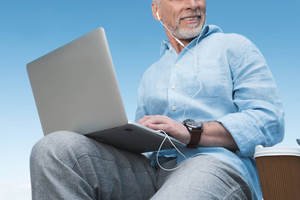 uomo anziano che lavora su computer portatile all'aperto
 - Foto, immagini