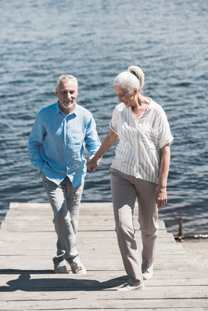 séta a folyóparton, mosolygó idős házaspár - Fotó, kép
