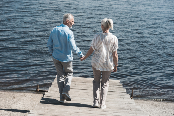 alkalmi idős házaspár, séta a folyóparton - Fotó, kép
