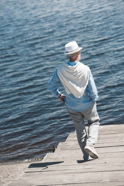 hombre mayor casual caminando a orillas del río
 - Foto, Imagen