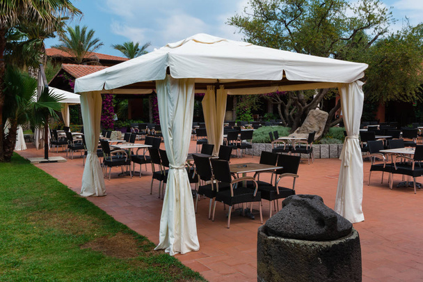 Stoelen en tafels onder de Gazebo met witte Tent - Foto, afbeelding