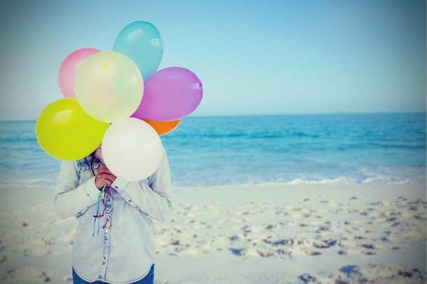 woman hiding her face with bunch of colorful balloons  - Foto, afbeelding