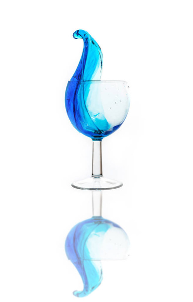 Μπλε ποτό σε ένα ποτήρι. Χυθεί υγρό. Ένα ποτήρι ποτό. - Φωτογραφία, εικόνα