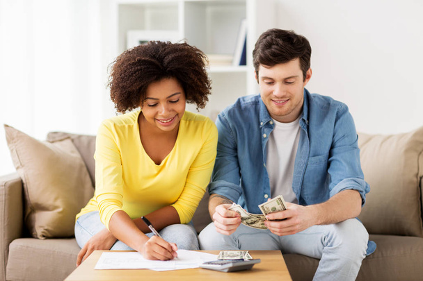 happy couple with papers and calculator at home - Foto, Imagem
