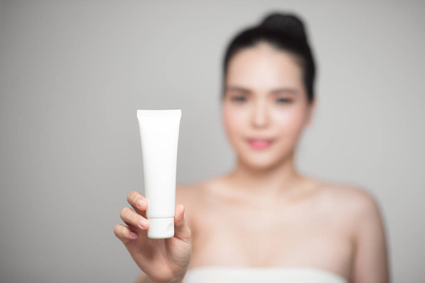 woman holding moisturizer tube. - Foto, Bild