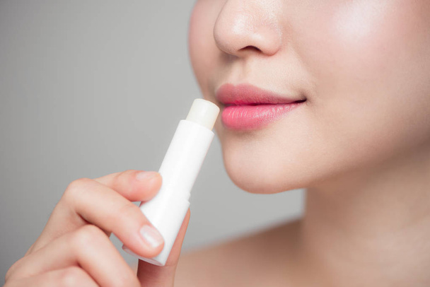 woman applying hygienic lip balm  - Фото, изображение