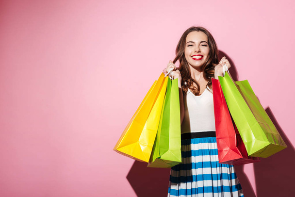 Happy girl carrying colorful shopping bags - Fotó, kép