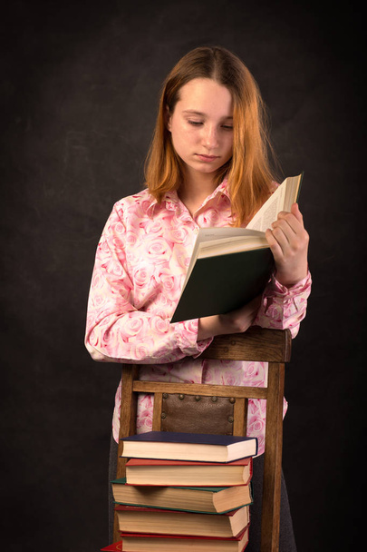 Πορτρέτο ενός εφήβου κοριτσιού ανάγνωση του βιβλίου. Στοίβα από βιβλία. - Φωτογραφία, εικόνα