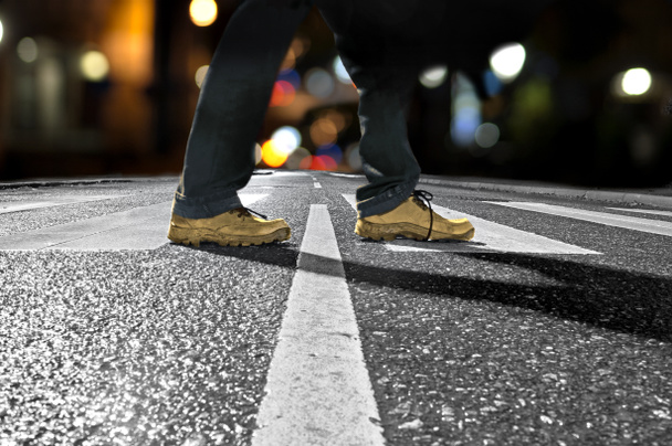 man kruising straat 's nachts - Foto, afbeelding