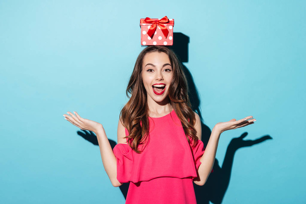 Girl in dress with a gift box on her head - Foto, imagen