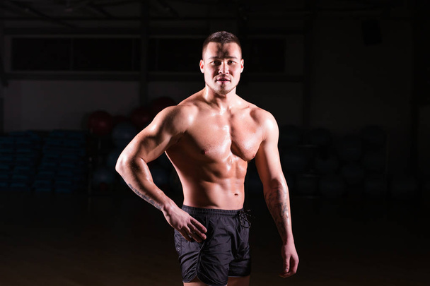 Ισχυρή αθλητικό κορμό μοντέλο Fitness άνθρωπος δείχνει abs έξι πακέτων στο γυμναστήριο - Φωτογραφία, εικόνα