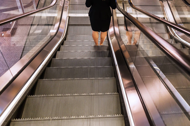 escalator with legs of a woman - Foto, Bild