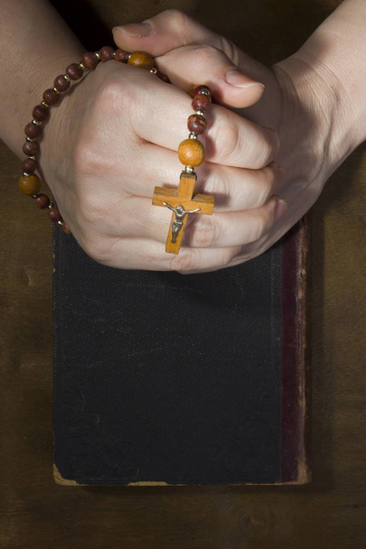 Hands with rosary and an old book - Valokuva, kuva