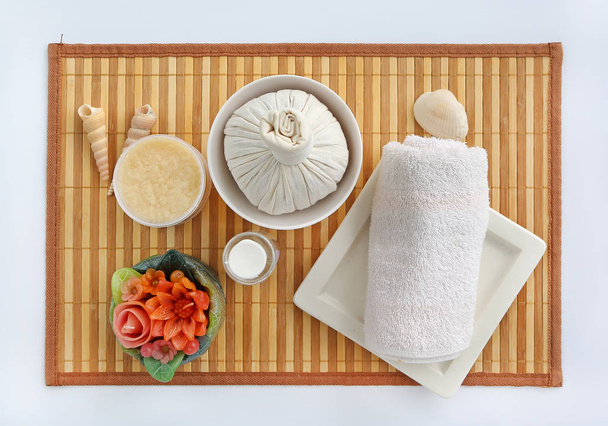 Spa herbal compressing ball with towels and Salt Scrub, Spa concept on bamboo board against white background - Photo, Image