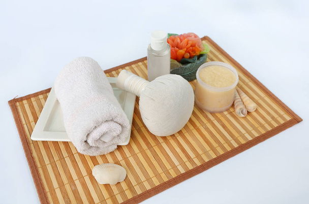 Spa herbal compressing ball with towels and Salt Scrub, Spa concept on bamboo board against white background, Top view - Foto, afbeelding