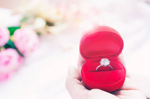 Frau hält Ehering in roter Schachtel, Hochzeits- oder Verlobungskonzept - Foto, Bild