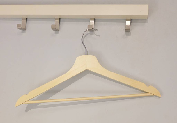 Houten kleerhanger hangen op een rek van kleding  - Foto, afbeelding