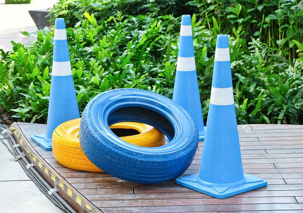 Cones azuis com pneus pintados de azul e amarelo
 - Foto, Imagem