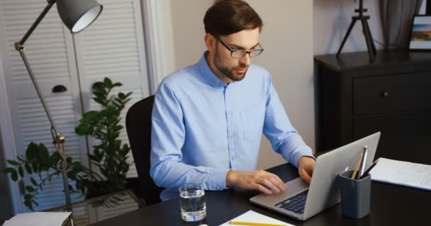 Mladý muž pracuje na svůj přenosný počítač v kanceláři. Obchodní muž psaní na notebooku. Office pozadí. - Záběry, video