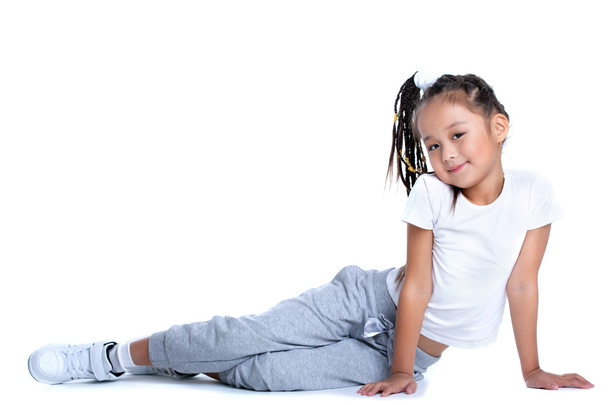 Asian little girl in sportswear sitting on floor - Foto, Bild