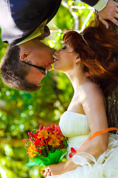 sposo appeso a testa in giù da un albero e bacia la sposa unusu
 - Foto, immagini