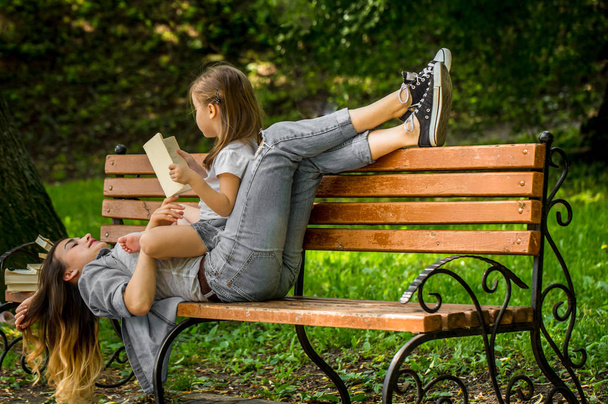 Mom and daughter on a bench reading a book - Photo, Image