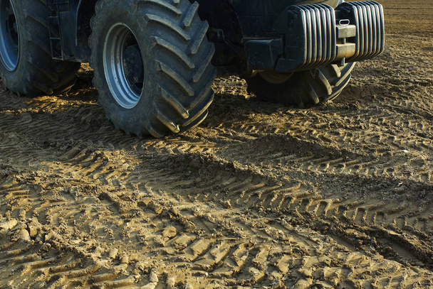 Vidéki mező traktorkerékkel a földön  - Fotó, kép