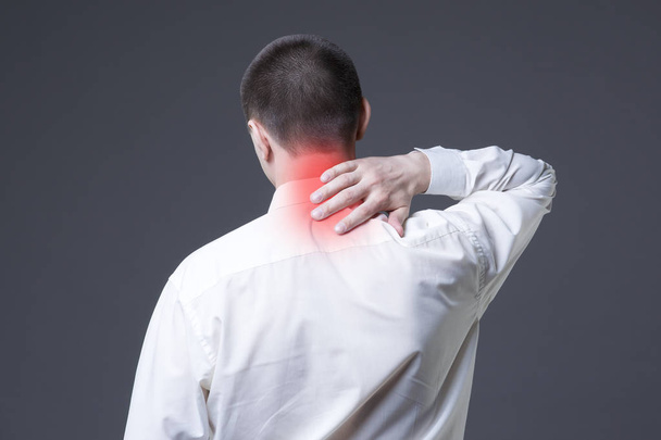 Neck pain, man with backache on gray background - Photo, image