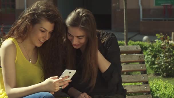 Dziewczyna pokazuje jej przyjaciel, coś na jej telefon - Materiał filmowy, wideo