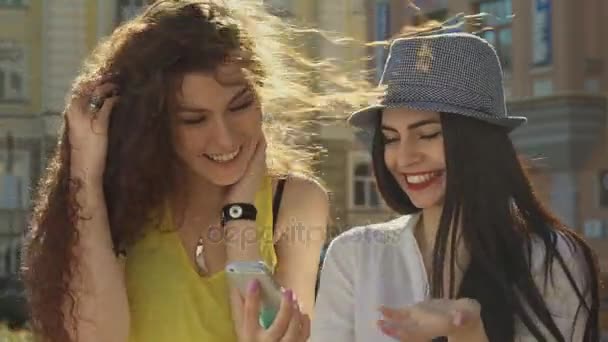 Dos chicas discuten algo en el teléfono inteligente
 - Metraje, vídeo