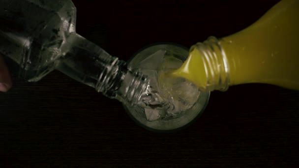 Slow mo. gleichzeitig Wodka und Saft in ein Glas gießen - Filmmaterial, Video