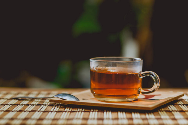Xícara de chá de vidro, colher de chá na mesa de madeira
. - Foto, Imagem