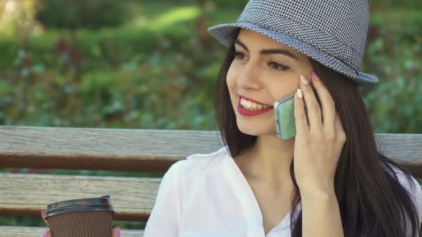 Girls talks on the phone on the bench - Video, Çekim